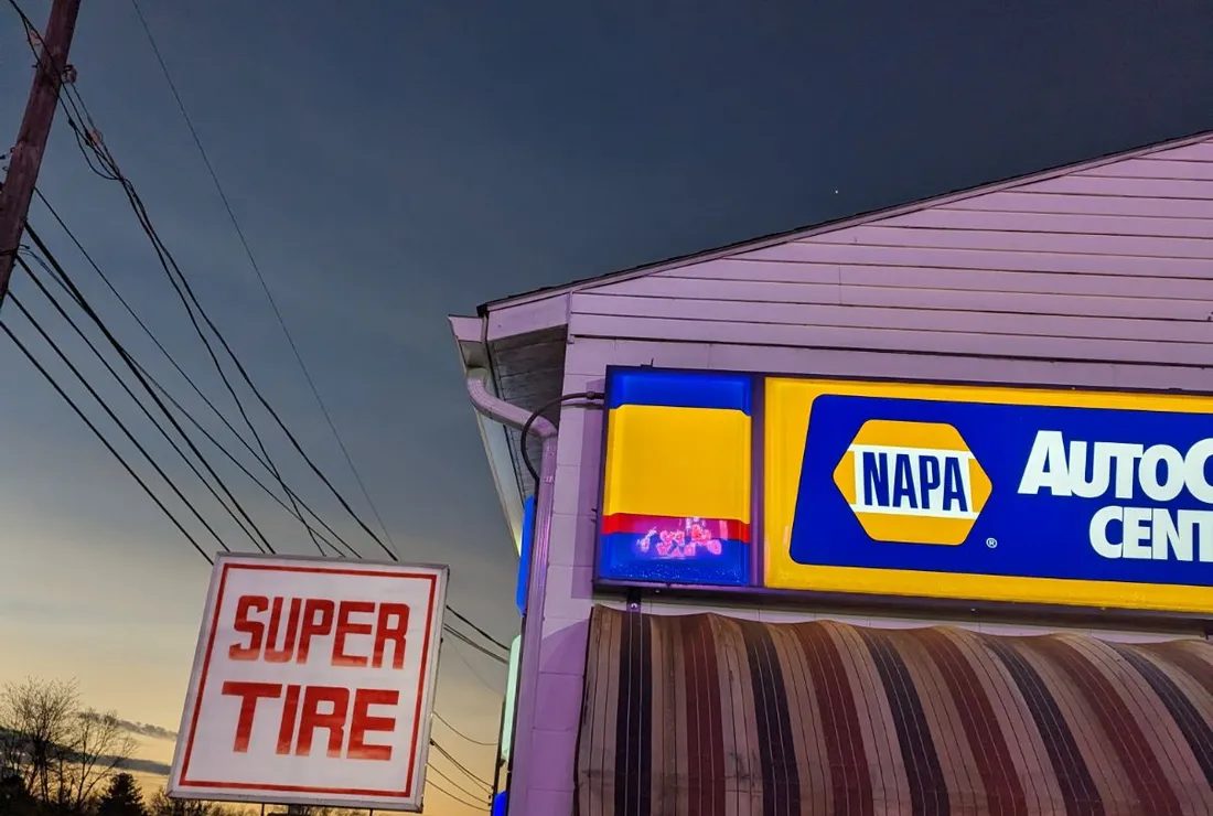 The lit NAPA AutoCare and Super Tire & Muffler sign in Cortland, OH